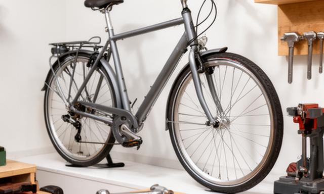 Bicicleta de cidade em exposição junto a acessórios e ferramentas de oficina