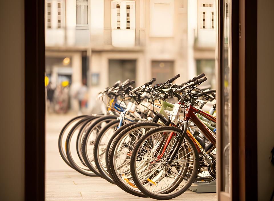 Bicicletas alinhadas à entrada da oficina na Rua da Geira, em Amares, com luz natural suave