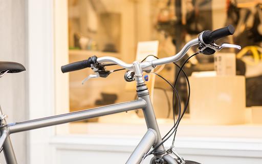 Bicicleta urbana encostada junto a montra luminosa na loja de Amares