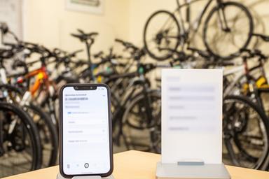 Telefone e formulário de contacto perto de bicicletas expostas numa loja em Amares